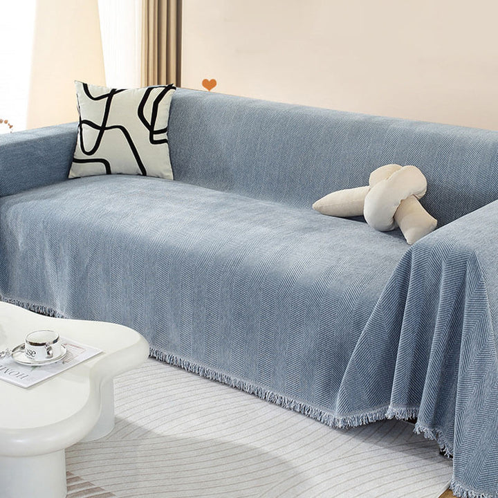 Corner detail of sofa protector featuring chenille material and stylish tassel fringe