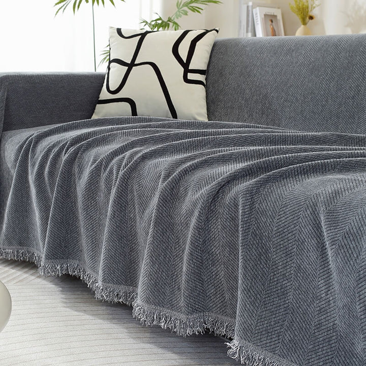 Living room sofa covered with a chenille herringbone throw, enhancing home decor