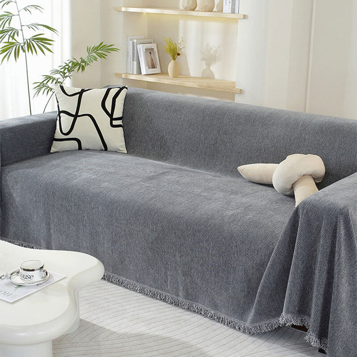 Beige chenille couch cover with subtle herringbone design and Tassel accents for sofa protection