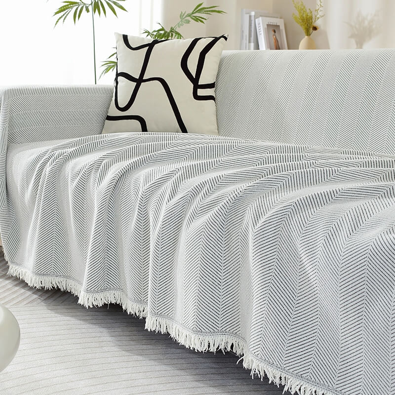 Full view of a couch adorned with a luxurious chenille herringbone tassel couch cover