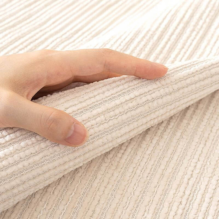 Angled view of a scratch-resistant chenille couch cover, fitting snugly over a sofa
