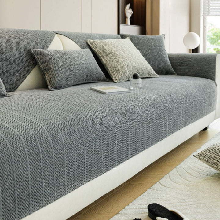 Chenille sofa cover in a neutral color, draped over a living room sofa, offering pet protection