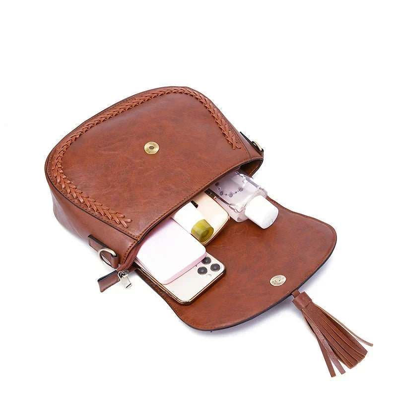 Elegant white women's saddle bag, a versatile crossbody style with a charming tassel detail.