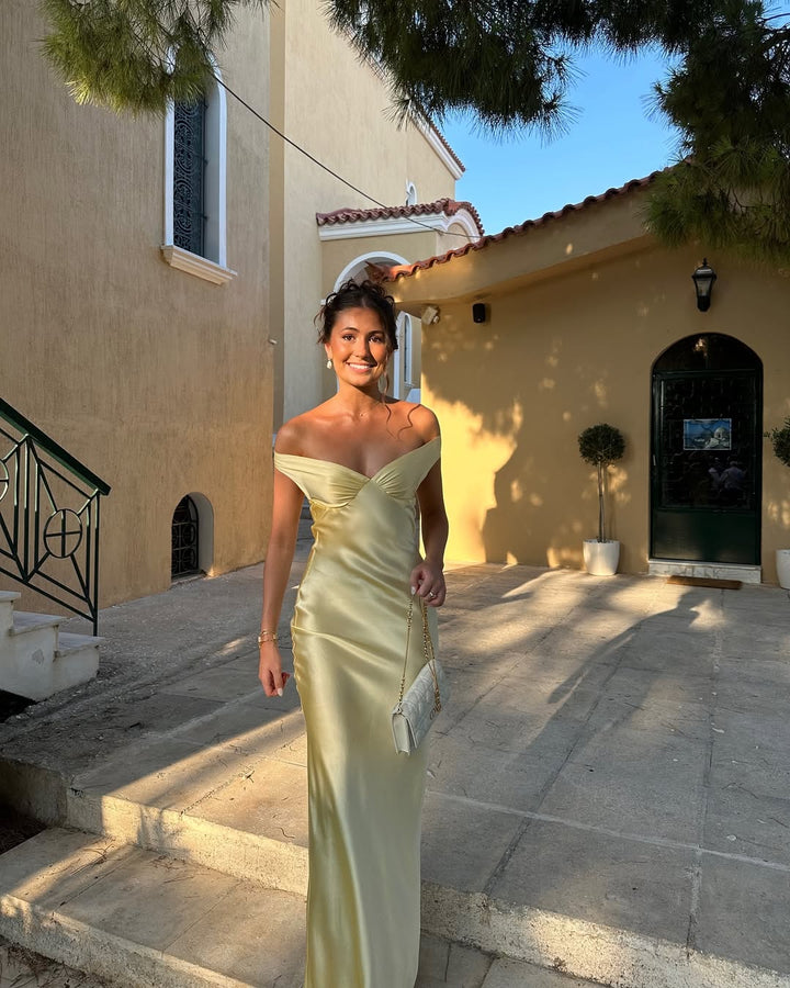 Formal gold maxi wedding guest dress for women. Chic off-shoulder design with sweetheart neckline, perfect for evening wear.