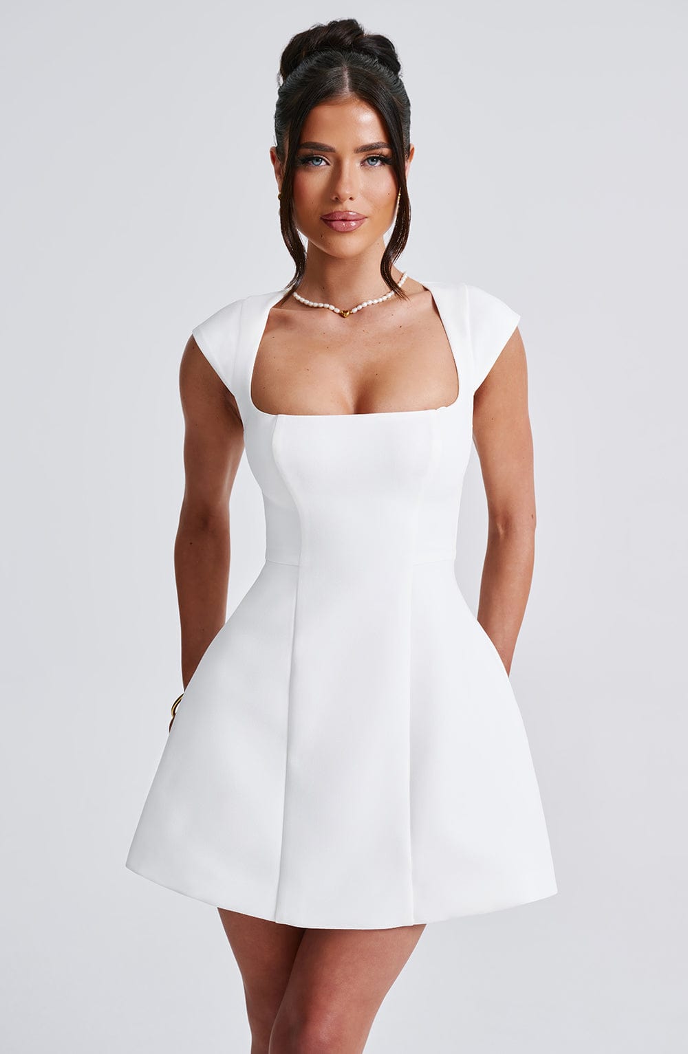 Chic white sleeveless mini dress for women. Modern & versatile style, perfect for summer parties & elegant occasions.