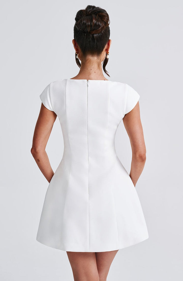 Elegant women's white mini dress with a modern sleeveless cut. Versatile for summer fashion, parties, or chic events.