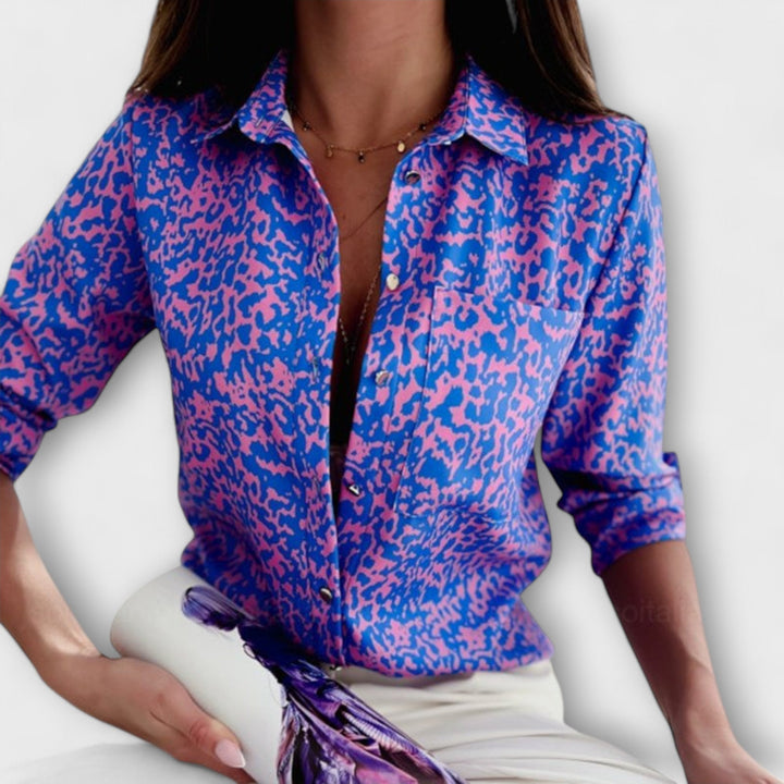 Elegant women's abstract print button-down blouse styled for a dressy occasion.
