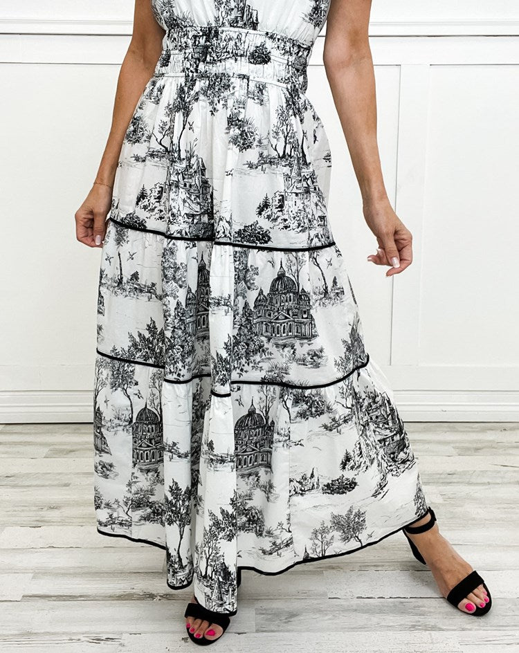 Chic women's wedding guest attire: printed tiered maxi dress with puff sleeves and smocked waist detail.