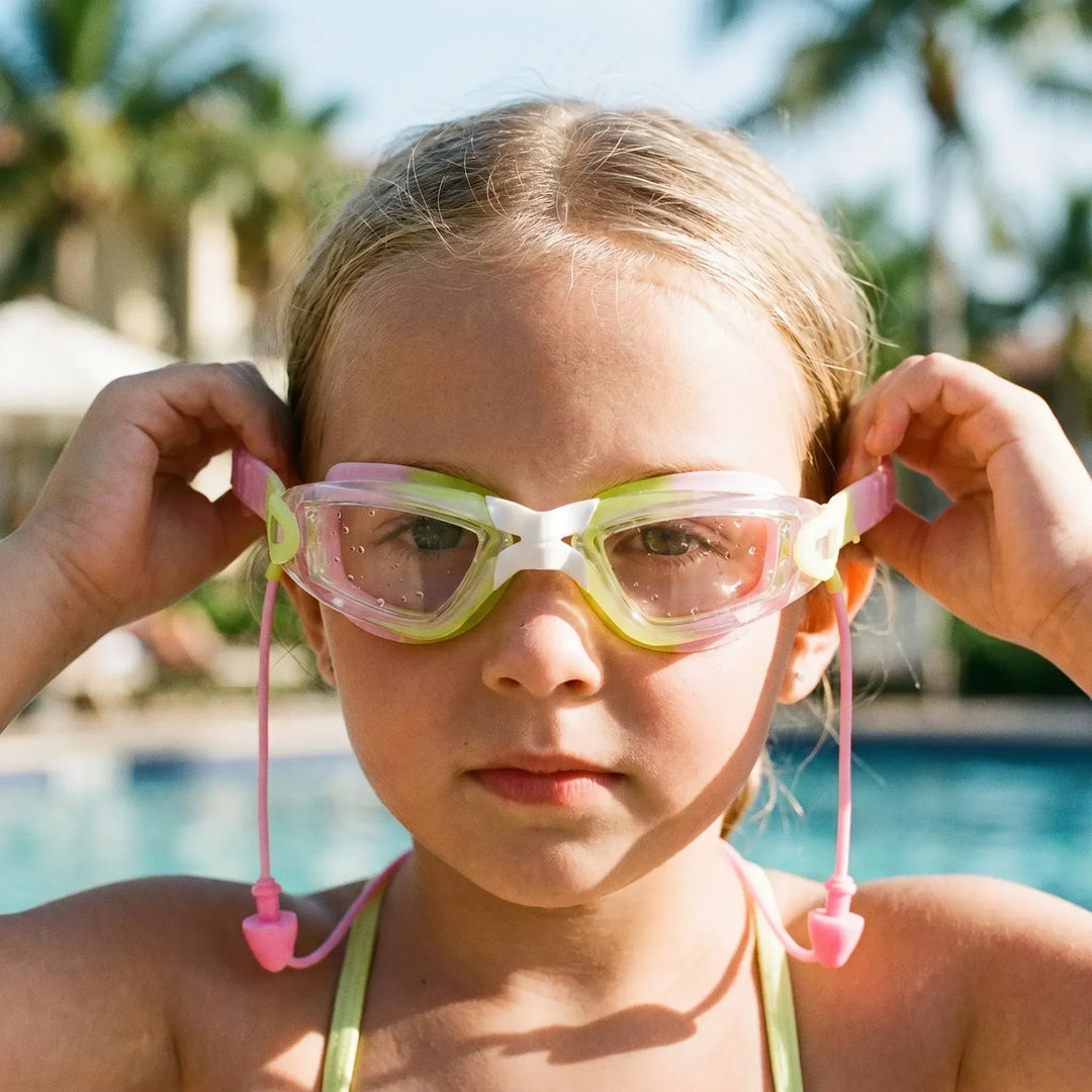 Children's anti-fog swim goggles with integrated earplugs for clear vision and ear protection in the pool.