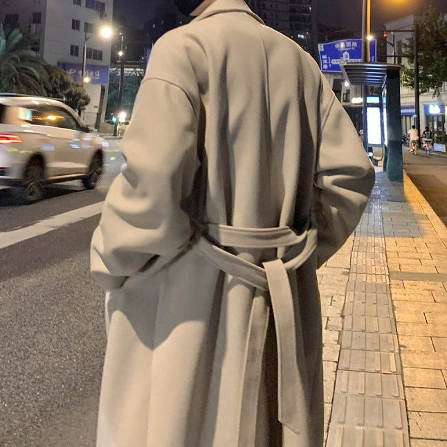 Back view of a men's classic long trench coat, showcasing the tailored design & quality fabric.