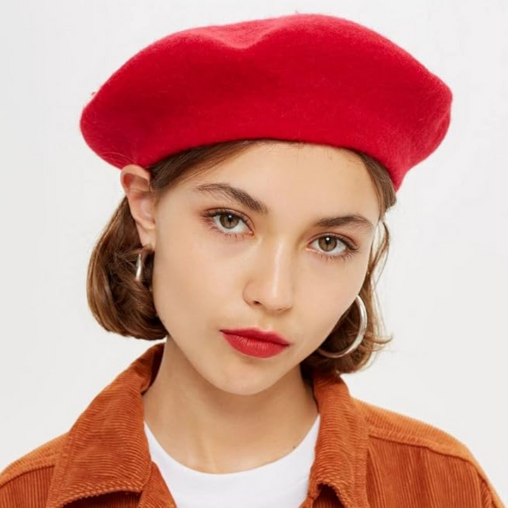 Delicate women's beret hat in a light shade, a classic French fashion accessory.