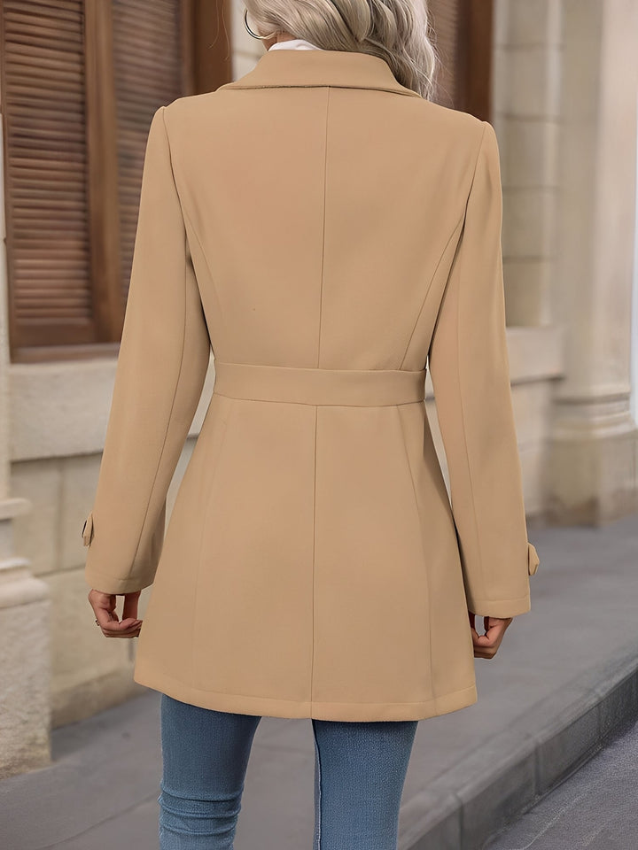 Beige women's elegant trench coat, double-breasted, with a sophisticated notch collar & belted waist.