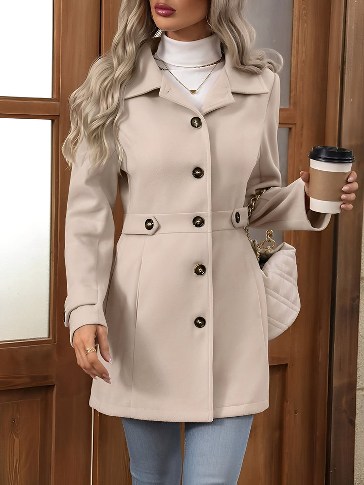 Detail of the notch collar and double-breasted front on a classic women's elegant trench coat.