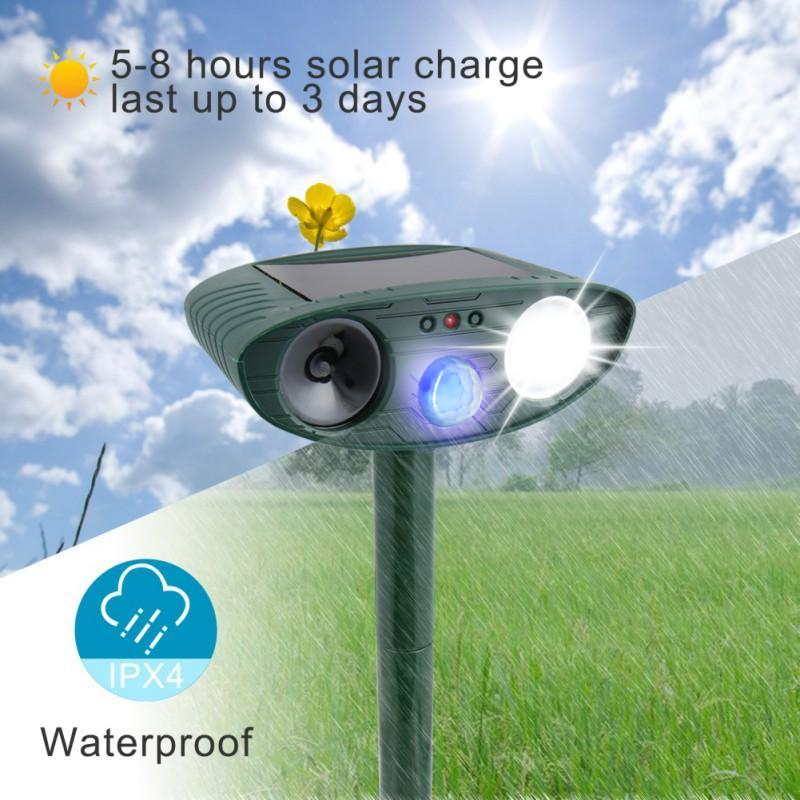 Solar-powered ultrasonic deer repeller protecting a vegetable patch from unwanted animals.