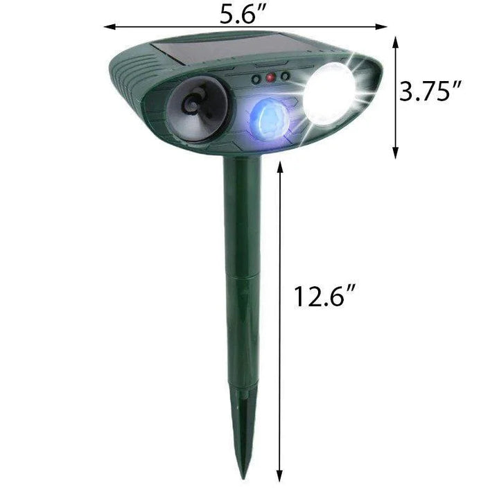 Outdoor animal deterrent: a black ultrasonic deer repeller stakes into the ground near shrubs.