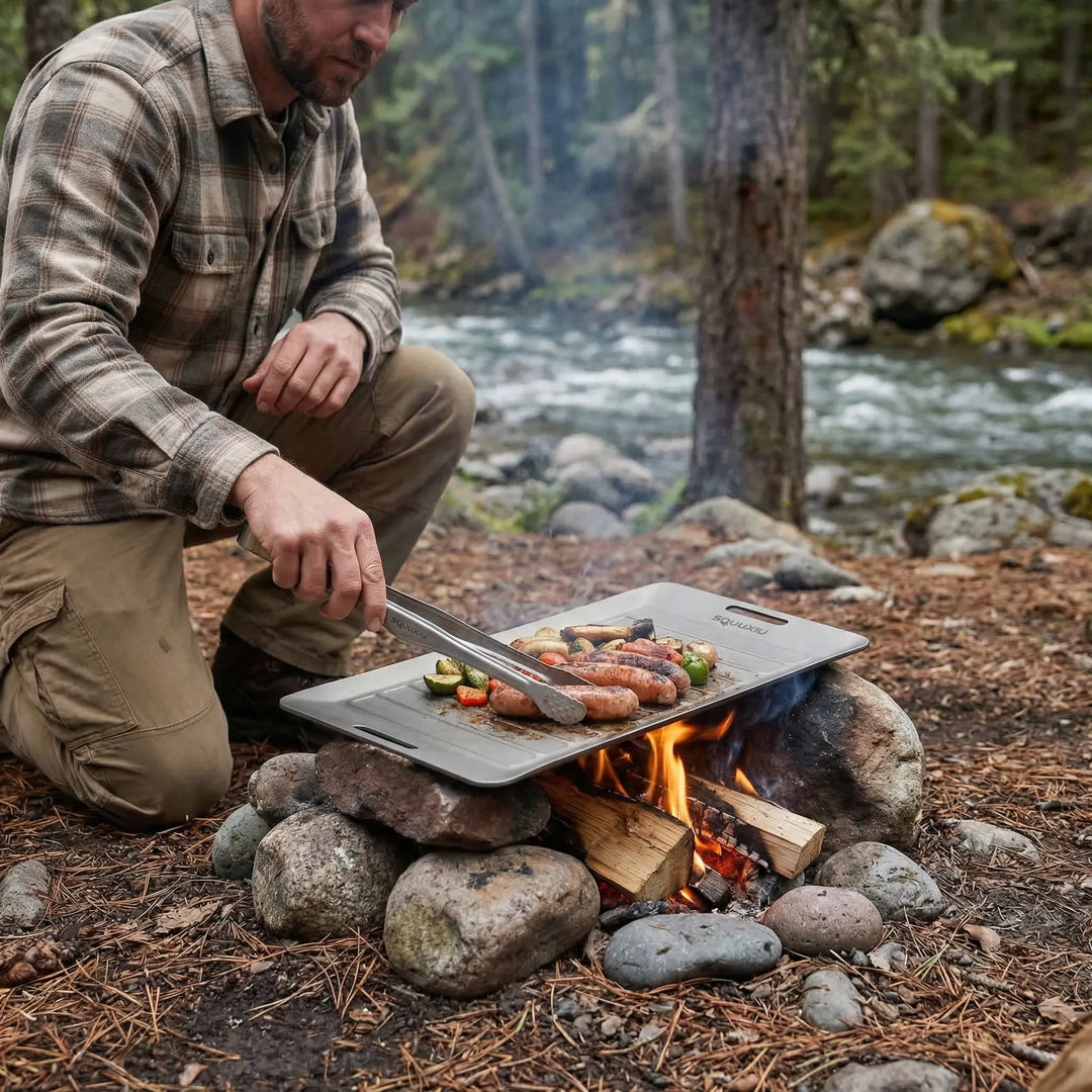 Compact camping grill plate with non-stick surface & stainless steel tongs for outdoor cooking.