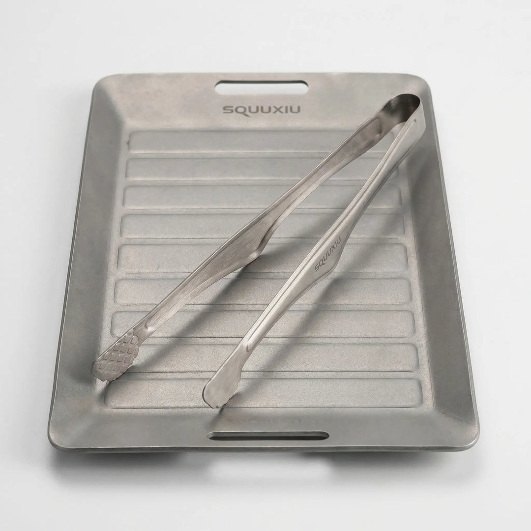 Lightweight compact grill plate with tongs for backpacking and outdoor culinary experiences.