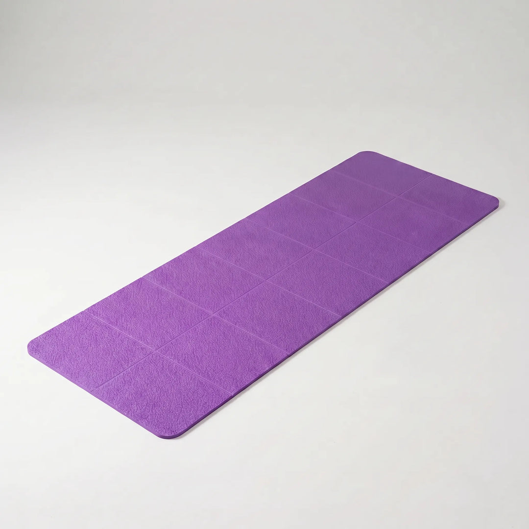 Portable TPE yoga mat rolled and ready for travel, perfect for fitness & exercise on any adventure.