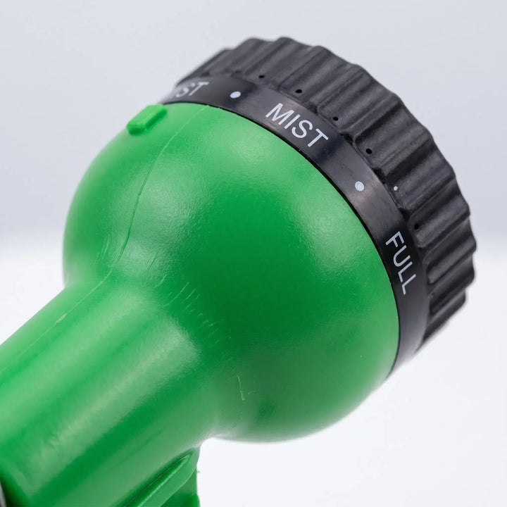 Retracting compact green coiled hose, ideal for watering plants, gardens & general outdoor cleaning tasks.