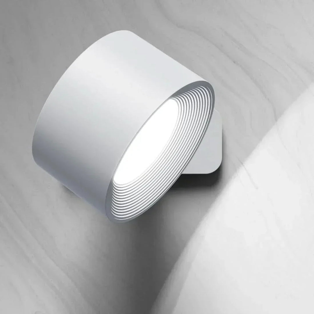 Contemporary cordless LED wall light featuring a magnetic mount, rechargeable battery, & pivoting design.
