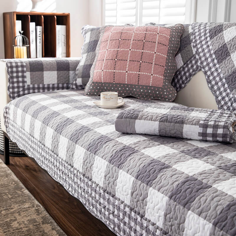 Full view of a living room with a cotton plaid sofa cover, protecting furniture from pets.