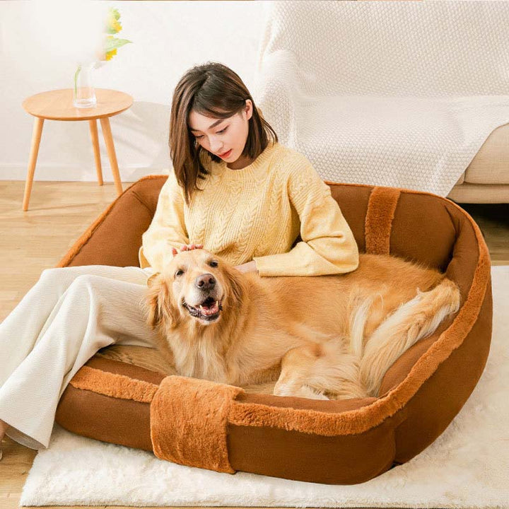 Pet bed for anxiety, a soft, cozy sofa bed with raised support in a light neutral color.