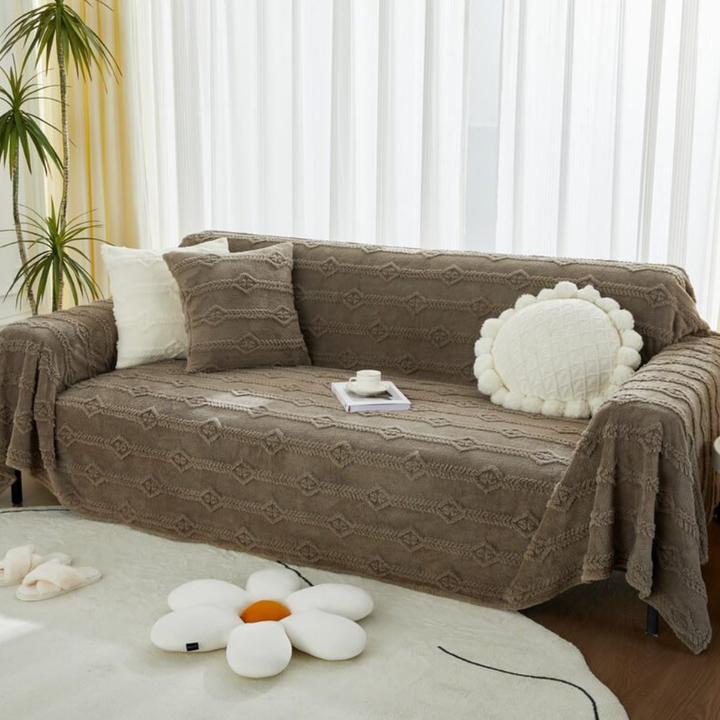 Machine washable faux fur furniture protector, ideal for pet-friendly homes, draped over a three-seater sofa.