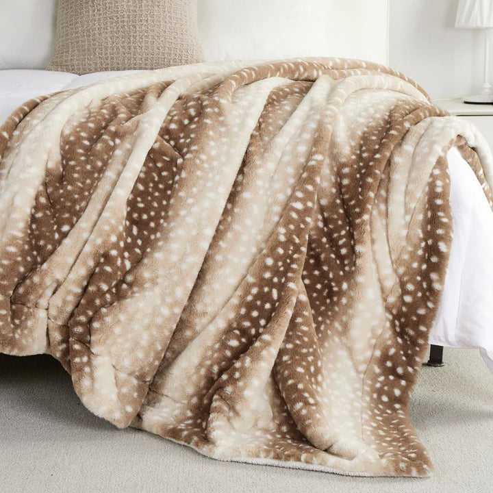 Luxurious faux fur deer print throw blanket, reversible plush design for cozy bedroom accent.