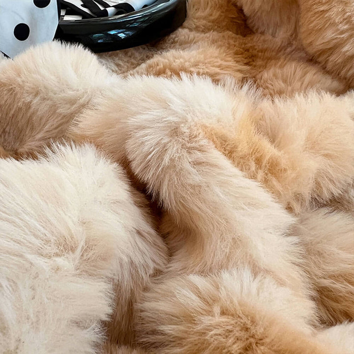 Soft faux rabbit fur fitted sheet on a queen-sized bed with matching pillowcases, close-up texture.