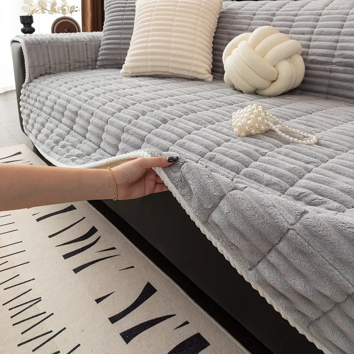 Flannel sofa cover with non-slip dots on the back, shown on a cream-colored couch.