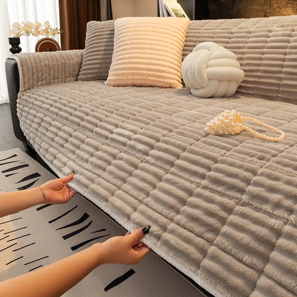 Stylish flannel sofa cover on a three-seater couch, offering comfort and pet protection.