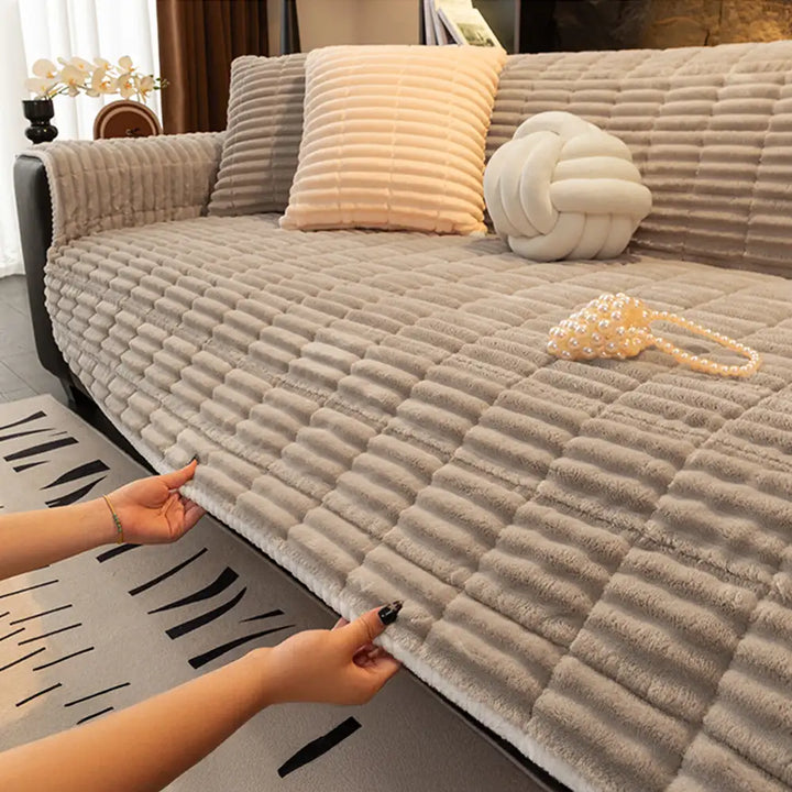 Stylish flannel sofa cover on a three-seater couch, offering comfort and pet protection.