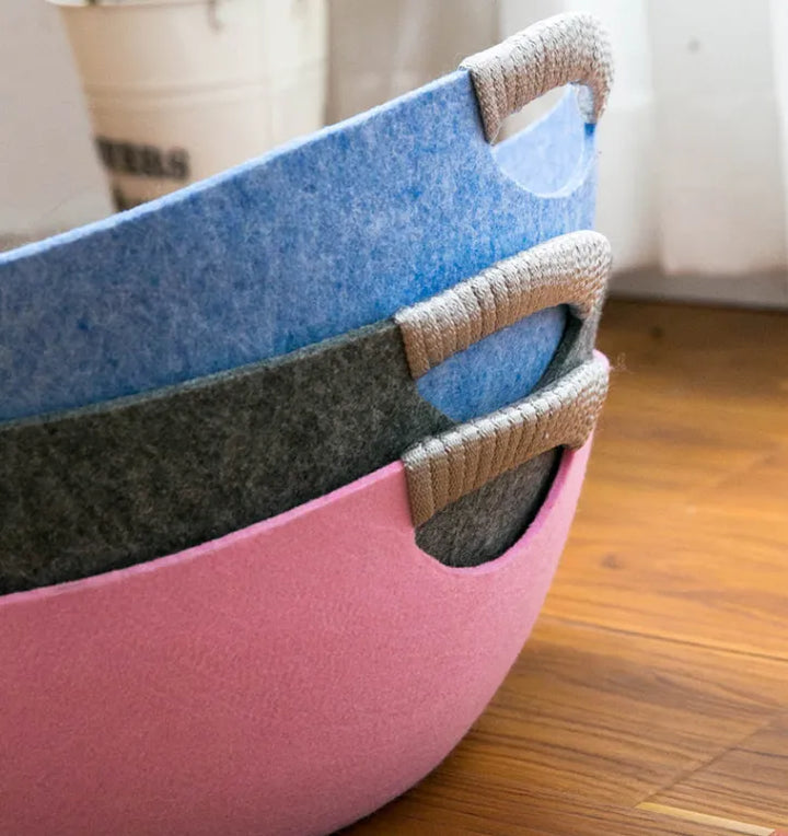 Round felt cat lounge with convenient handles, ideal for pet comfort and contemporary home decor.