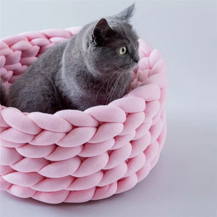 Soft, hand-knitted cat bed, an inviting animal house offering warmth and comfort to pets.
