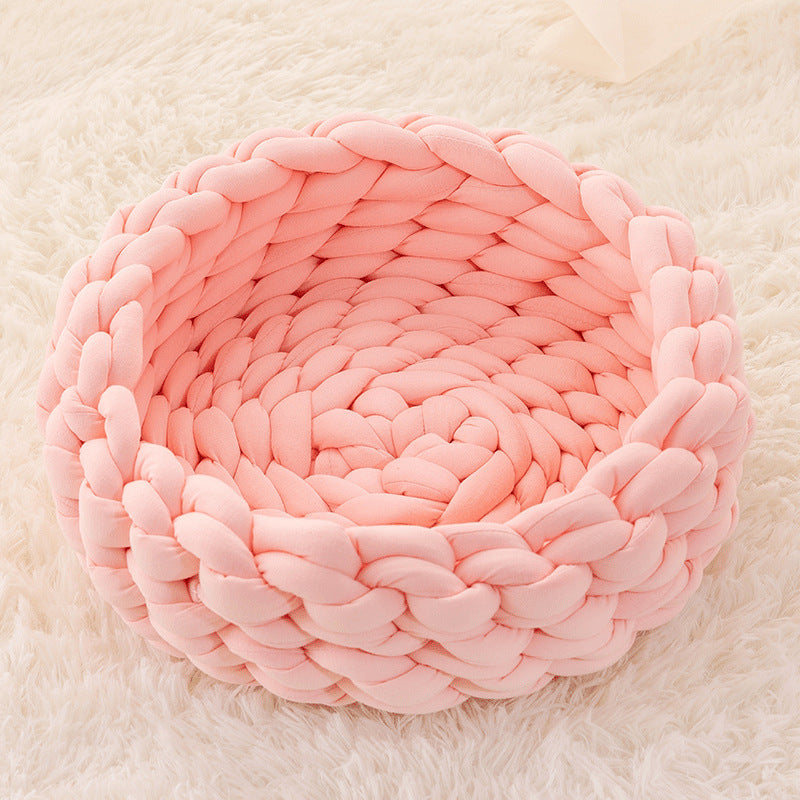 Round, handwoven knitted cat bed in a light color, ideal for any cat seeking a cozy spot.