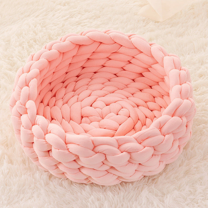 Round, handwoven knitted cat bed in a light color, ideal for any cat seeking a cozy spot.