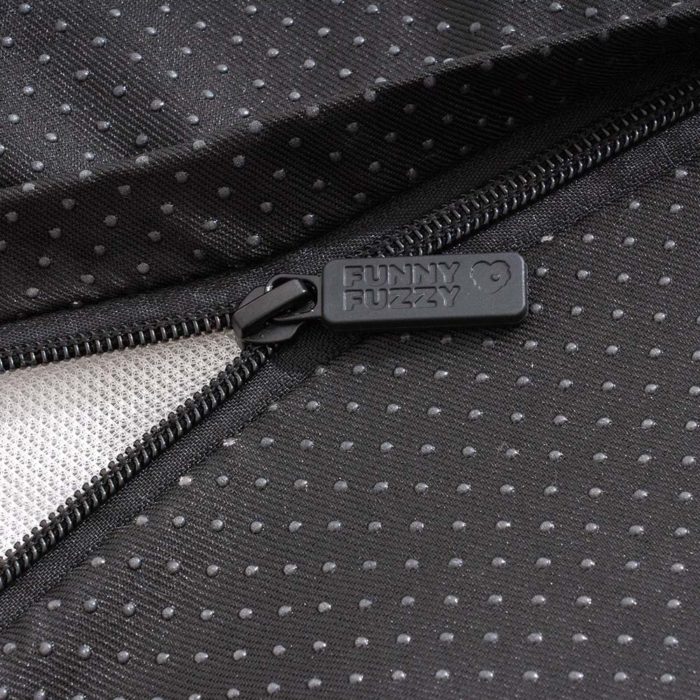 Close-up of the soft, fluffy texture of a washable pink dog bed with an embroidered paw print.