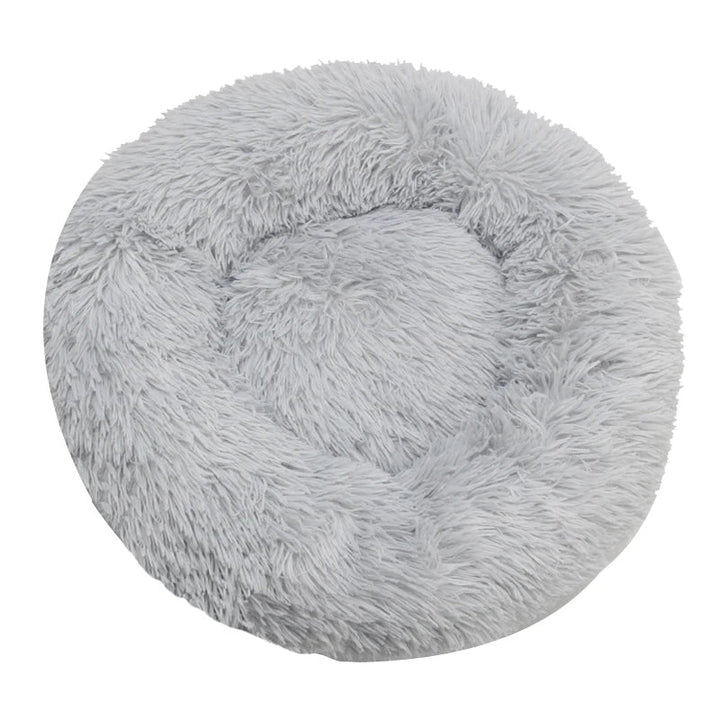 Gray plush round cat bed, a cozy donut shape inviting pets for a luxurious sleep.