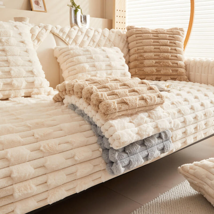 Cozy plush striped sofa cover in a living room, protecting a large sectional sofa from spills and pet fur