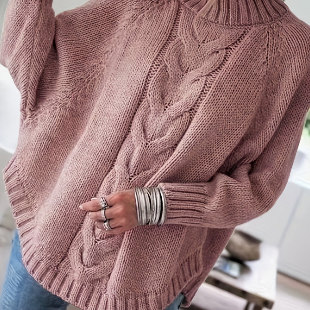 Oversized women's cable knit sweater for fall, high-neck, with unique batwing sleeves and flared hem.