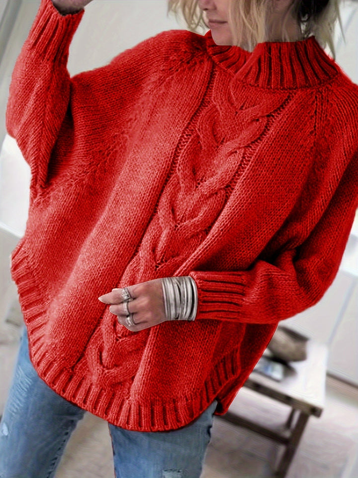 Full view of a women's oversized cable knit sweater with a fashionable flared hem, perfect for winter.