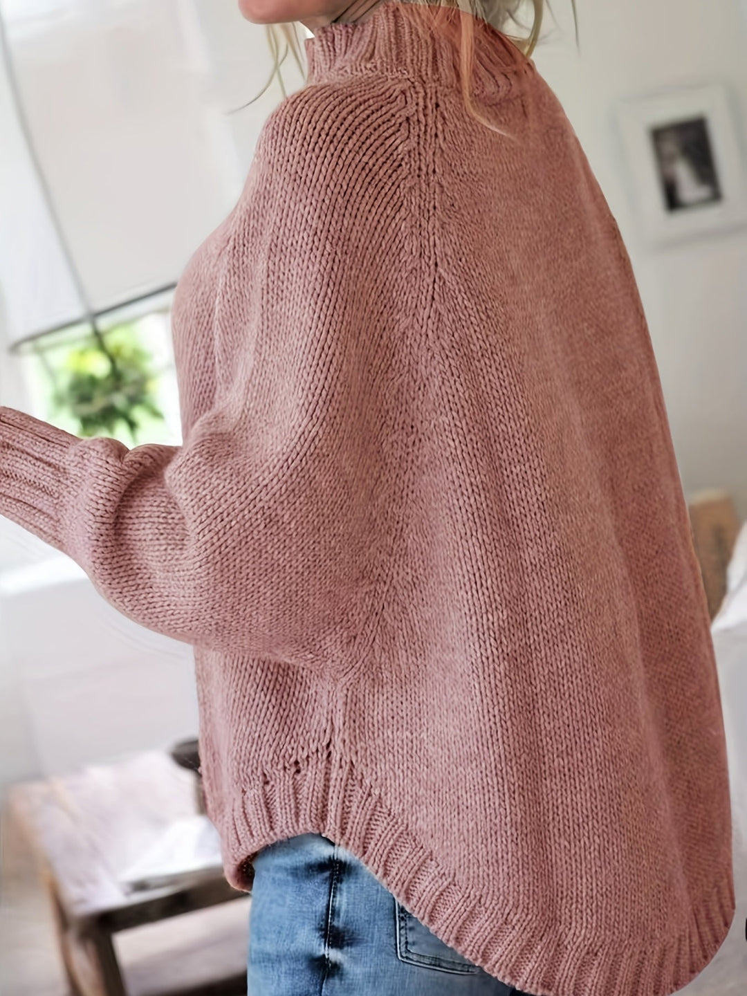 Detailed shot of the flared hem on a comfortable women's oversized cable knit sweater.