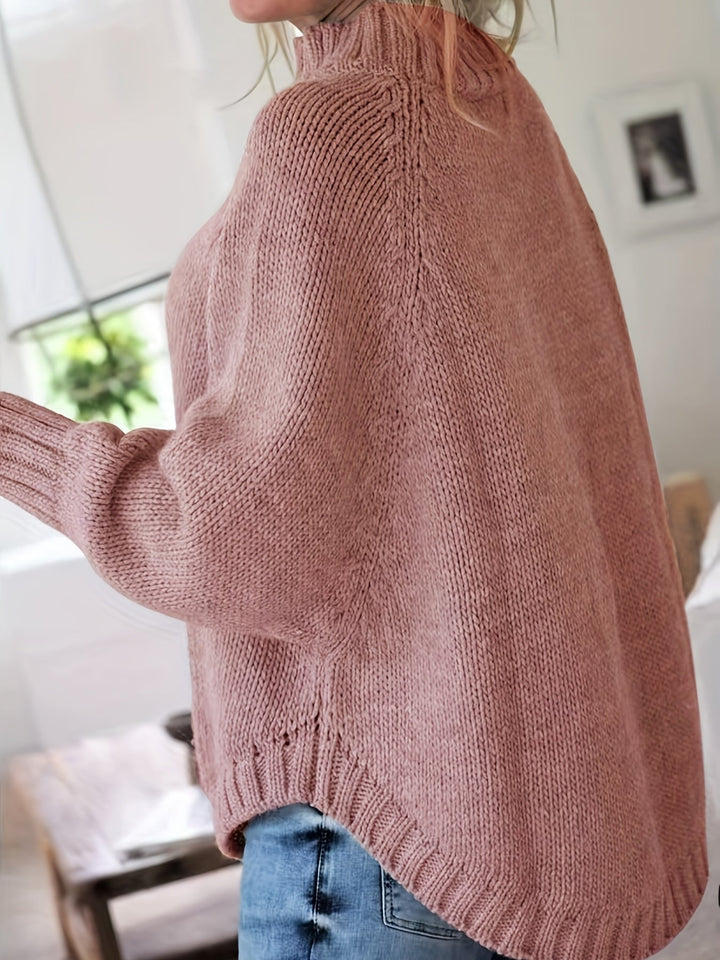 Detailed shot of the flared hem on a comfortable women's oversized cable knit sweater.