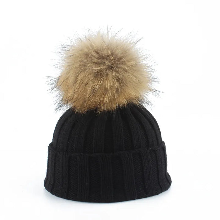 Cozy women's winter beanie hat with a fluffy faux fur pom-pom, perfect for cold weather.