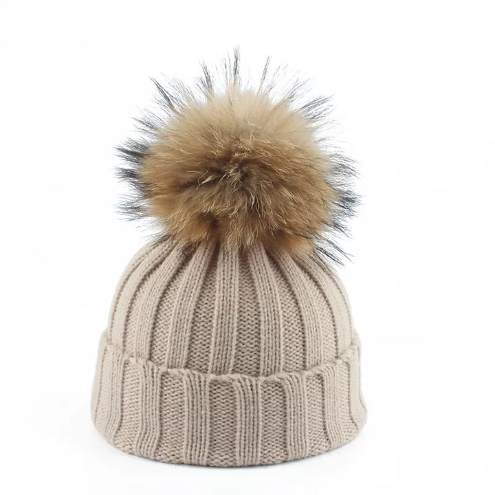 Women's warm winter beanie hat featuring a soft faux fur pom-pom for ultimate coziness & style.