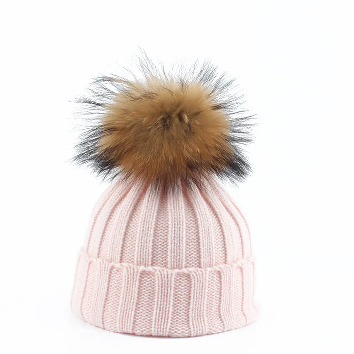 Soft knit women's winter hat, a cozy beanie with a prominent faux fur pom-pom for cold weather fashion.