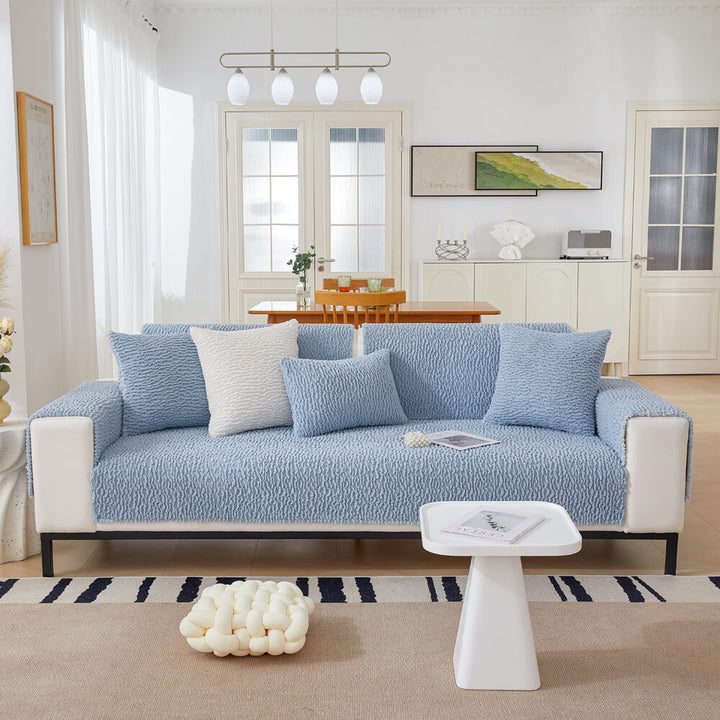 Cream berber fleece sofa cover draped over a modern couch, stylish home decor