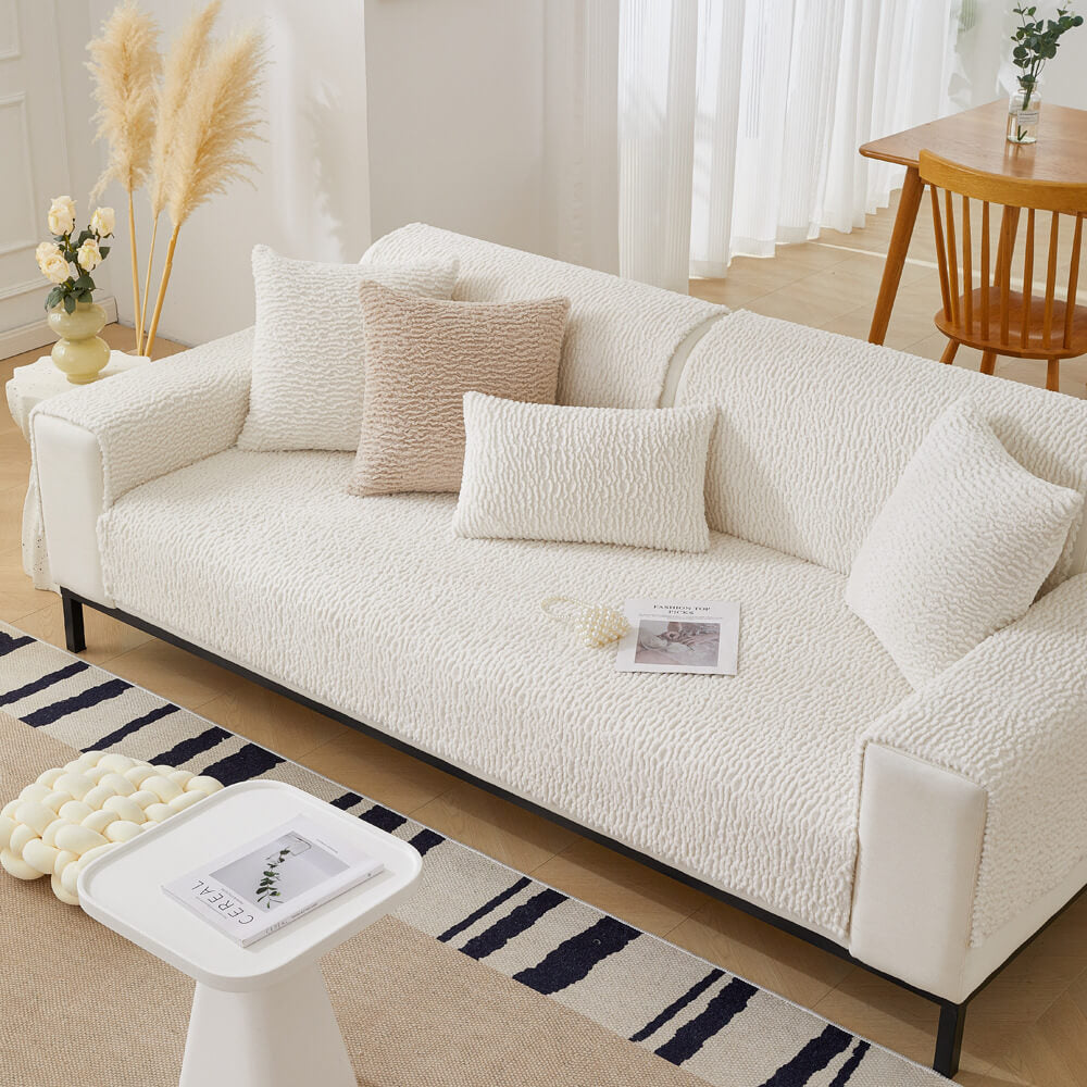Cream berber fleece sofa protector with elastic straps, ensuring non-slip fit