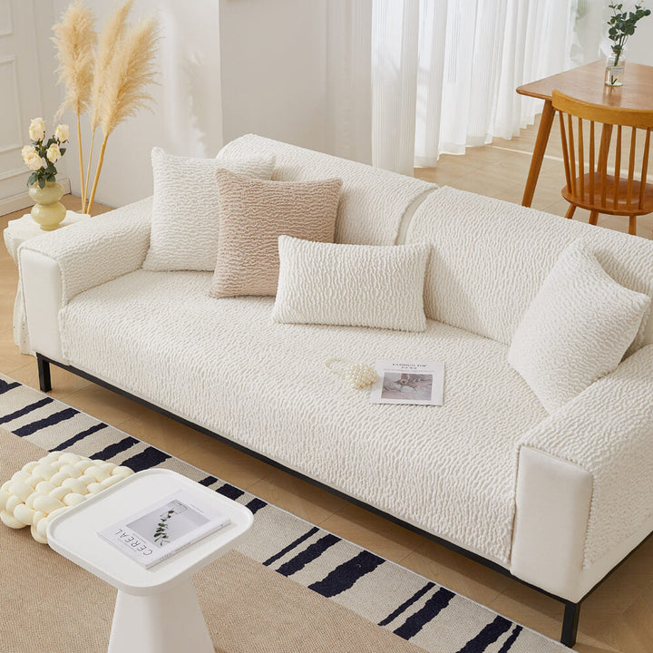 Cream berber fleece sofa protector with elastic straps, ensuring non-slip fit