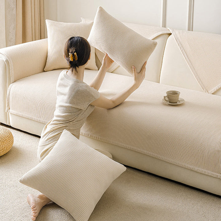 Cream fleece sofa cover with vertical stripes, a durable and pet-friendly furniture protector for families.